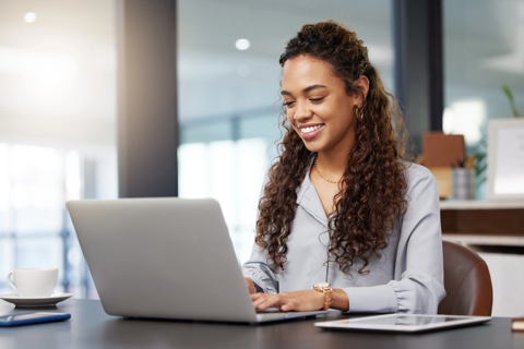 a woman sitting at a desk using a laptop