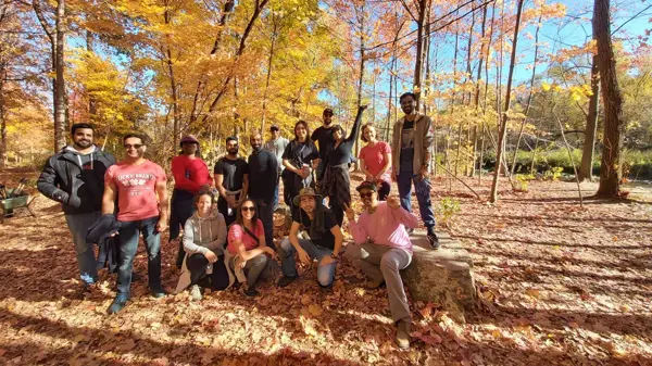 A group of people smiling and posing for a photo in a serene woodland setting.