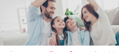 Una famiglia seduta sul pavimento della propria casa, sorridendo mentre si guardano l'un l'altro