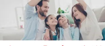 Une famille assise par terre dans leur maison, souriant en se regardant les uns les autres