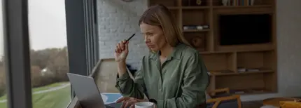 business woman working on laptop in cozy office while sitting near windows