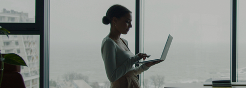 A person standing and working on their laptop doing margin planning with Prophix One FPA PLus