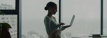 A person standing and working on their laptop doing margin planning with Prophix One FPA PLus