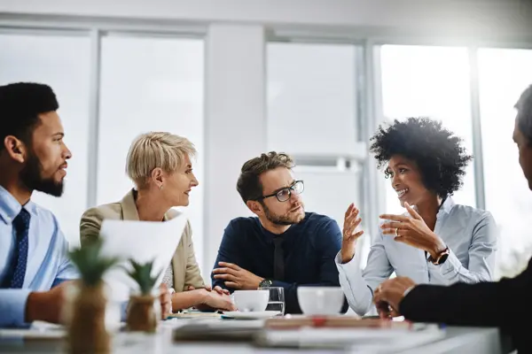 Business team gathered around a table discussing a report