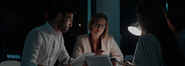 a group of people sitting at a table working in a corporate office