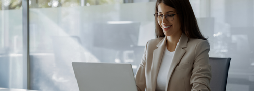 a person in a business suit is working on their laptop