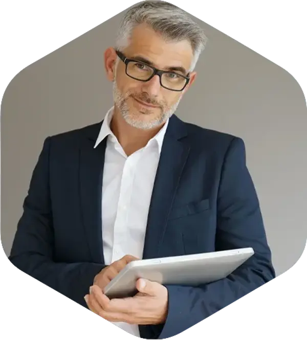 Un homme en costume et lunettes, tenant un iPad et souriant avec confiance