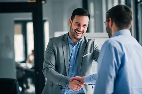 Deux professionnels se serrant la main et souriant