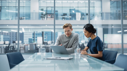 A man and a woman looking at a laptop together