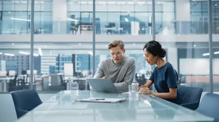 A man and a woman looking at a laptop together