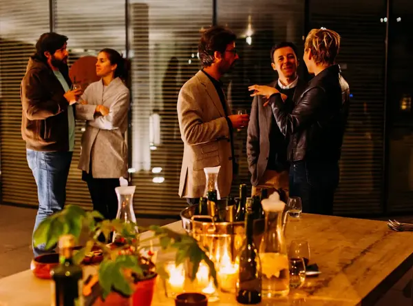 A group of professionals standing, engaging in conversation and networking outside of work