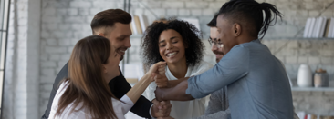 A team of professionals smiling as they join hands in the center