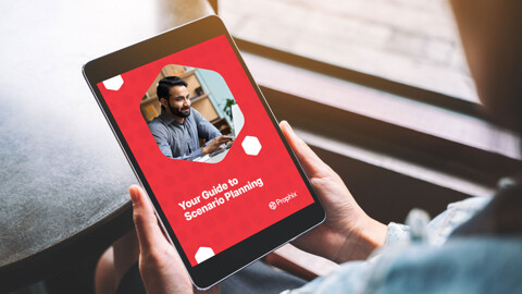A person is holding an iPad featuring an image of a man at his laptop