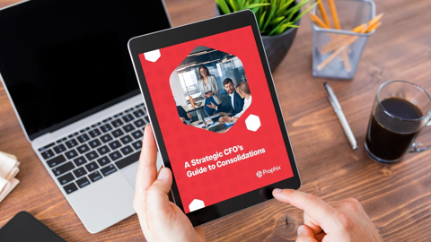 Een persoon houdt een iPad vast waarop een afbeelding te zien is van een groep professionals die samenwerken op het scherm
