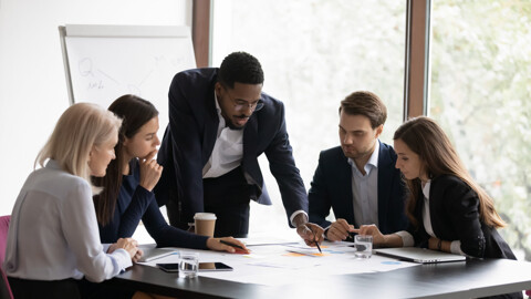 A group of professionals collaborating in a meeting, discussing business matters and working together to achieve common goals.