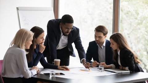 Un gruppo di professionisti che collaborano in una riunione, discutendo questioni aziendali e lavorando insieme per raggiungere obiettivi comuni