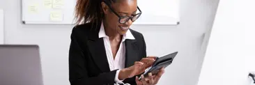 Une femme professionnelle en costume d?affaires est concentre sur sa tablette, engage dans son travail ou ses recherches
