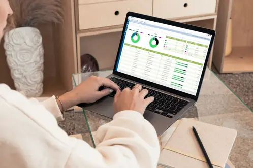Een persoon die zit en typt op zijn laptop