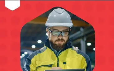Ein Mann mit Schutzhelm und Schutzbrille mit einem Tablet in der Hand, mit einer gelben Jacke, bereit, auf einer Baustelle zu arbeiten
