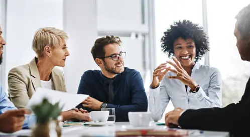 Un groupe diversifi de professionnels s?est runi dans une salle de confrence, collaborant et souriant tout en travaillant ensemble