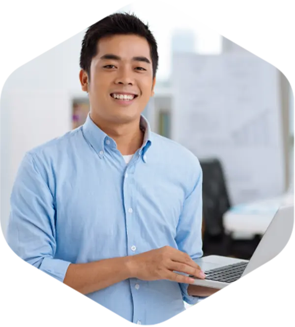 A man holding a laptop and smiling