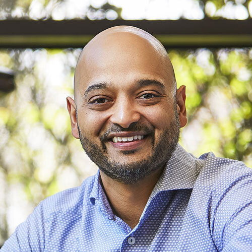A smiling professional man standing outdoors