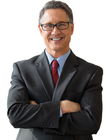 Ein Mann im Anzug, der steht, mit seinen Zhnen lchelt und die Arme verschrnkt