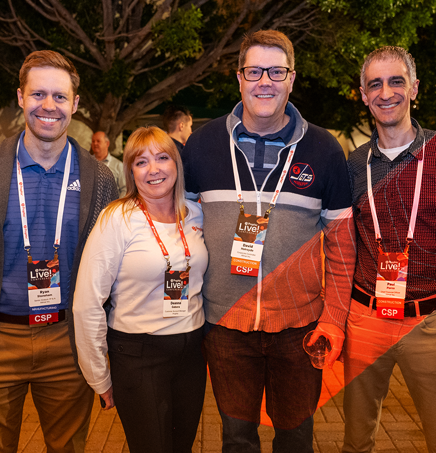 Three men and one woman standing together, smiling at the Prophix Live conference event