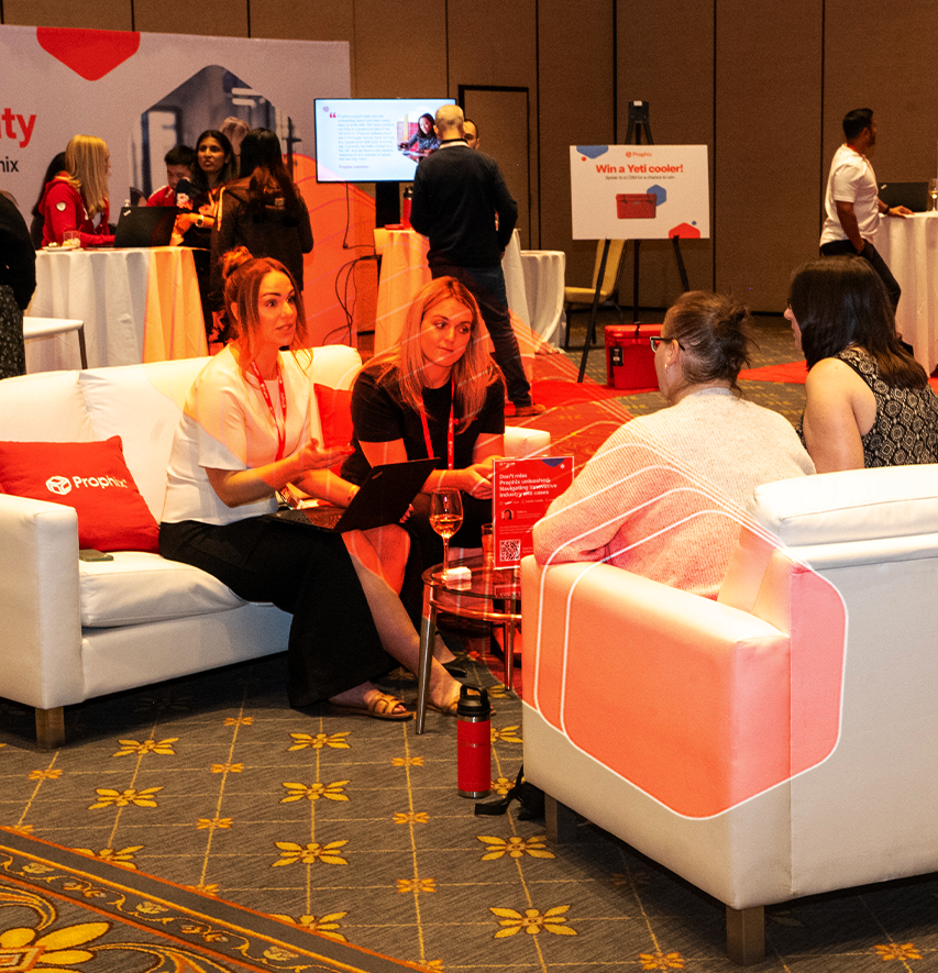 Four women seated on a white couch, chatting with each other at the Prophix Live conference event