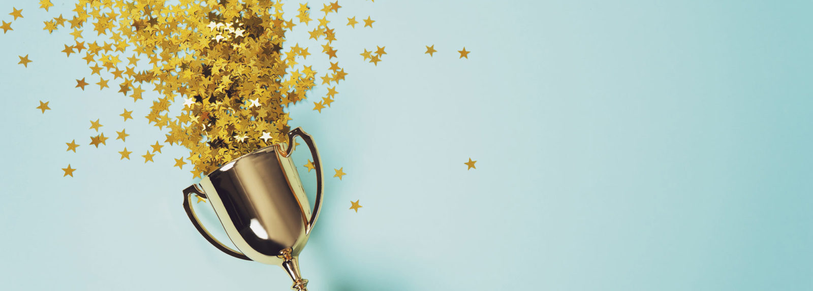 Golden stars emerging from a golden cup set against a light background