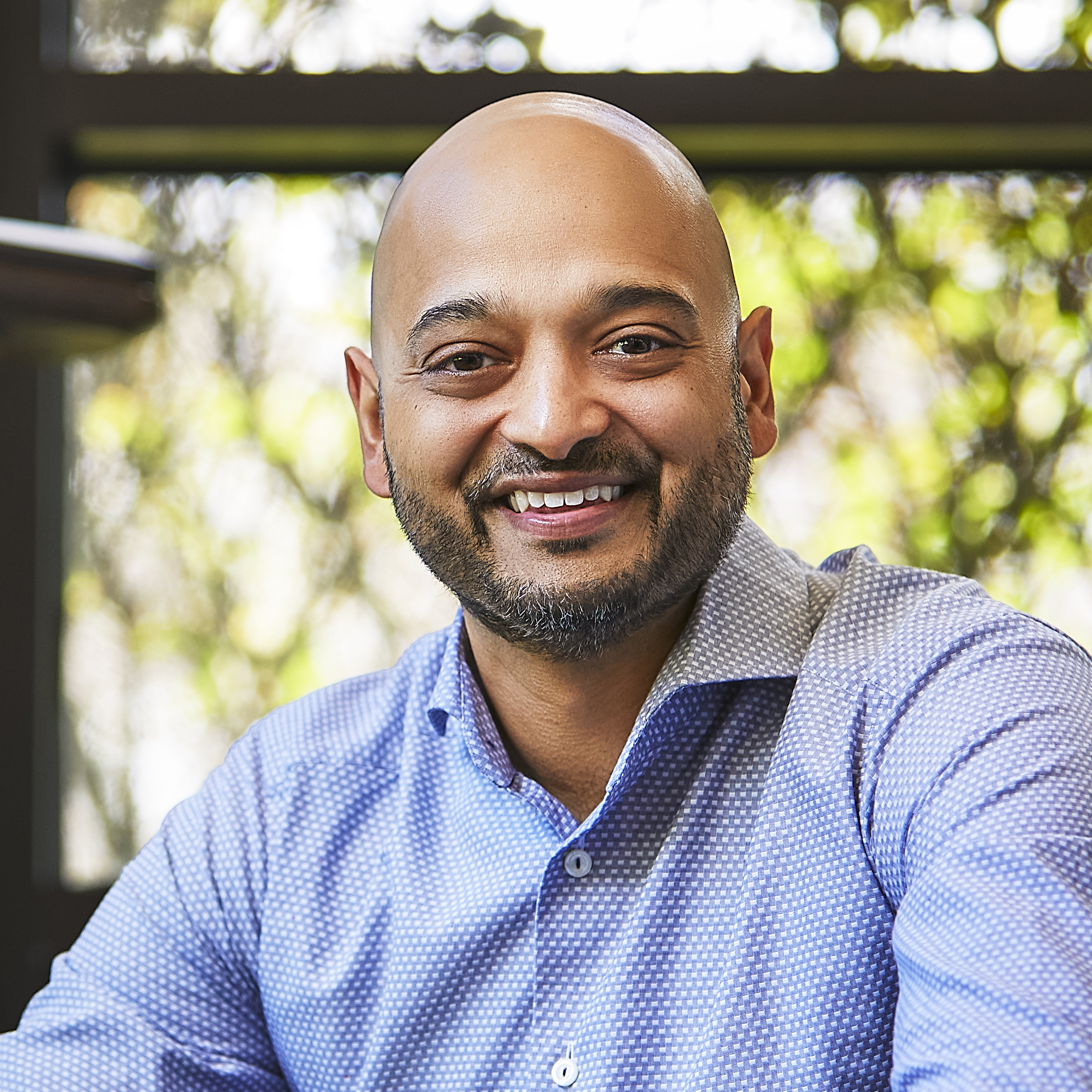 Prophix Alok Ajmera CEO of Prophix with a cheerful expression wearing a blue shirt.