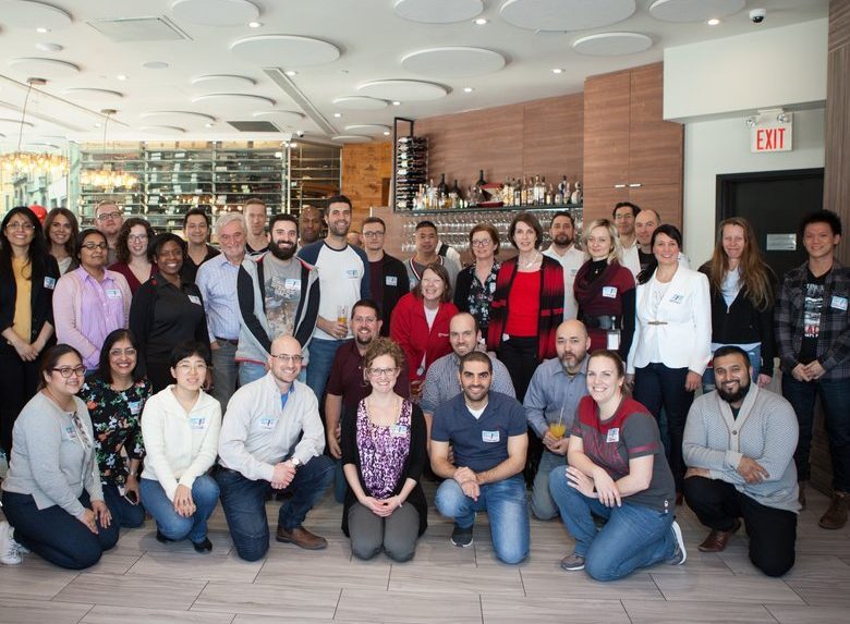 A large group of professionals smiling and posing together for a photo