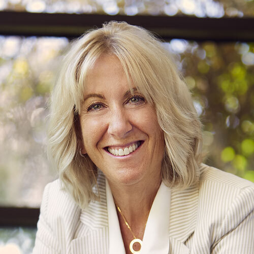 A woman with blonde hair smiling with her teeth